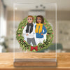 Ein ideales Geschenk für die Schwester: Ein personalisierter Acrylglasaufsteller mit zwei individuell gestalteten Figuren, eingefasst in einen Lorbeerkranz mit der Aufschrift 'SISTERS FOR LIFE', auf einem stilvollen Holzfuß präsentiert.